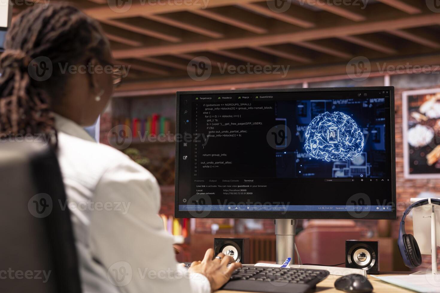Teleworking system administrator using computer for artificial intelligence computing through self learning algorithms. African american remote worker works with AI deep neural networks on desktop PC photo