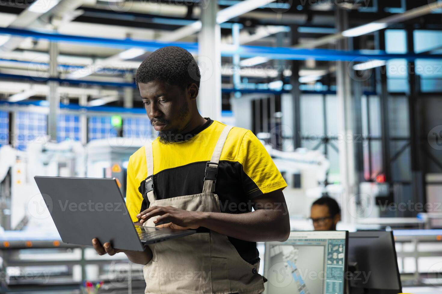 PC based solar specialist reviews automation data in production factory, manufacturing industry focused on renewable energy. Engineer tracking solar panels and machine performance. photo