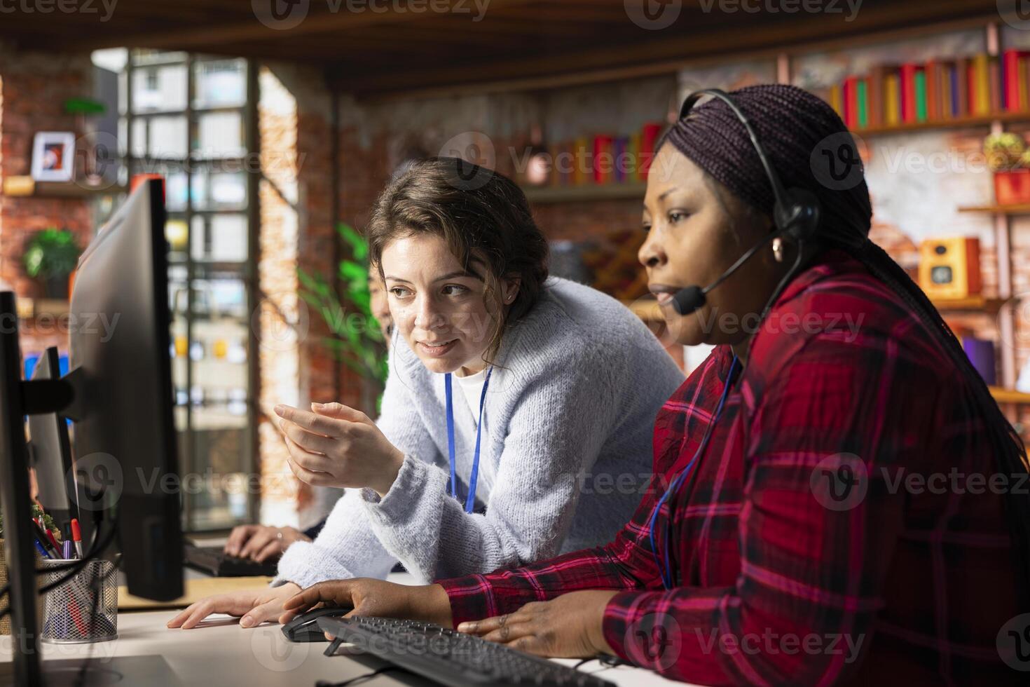 Cheerful call center onboarding specialist training worker on how to use computer software. Happy supervisor in customer support department office showing employee how to use company application photo