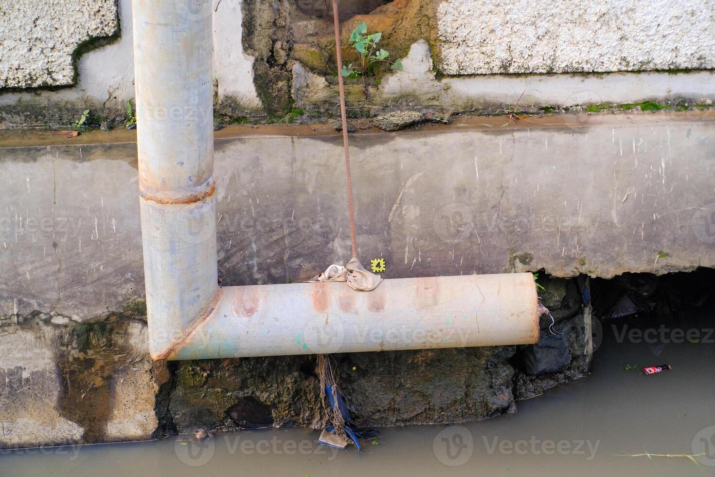 Iron pipe for drainage above the gutter. Waste drainage from a factory built in the area outside the factory area. Hazardous waste management. Health, Safety and Environment photo