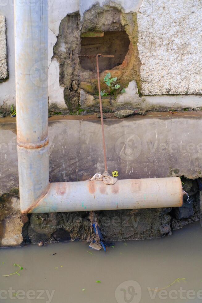L-shaped iron pipe for drainage above the gutter. Waste drainage from a factory built in the area outside the factory area. Hazardous waste management. Health, Safety and Environment. Copy space photo