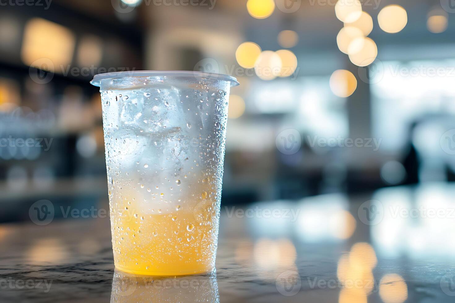 A glass of orange juice sitting on a bar counter photo
