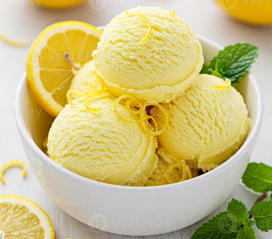 Close-up of a white bowl filled with three scoops of lemon creamy ice cream, garnished with a fresh lemon fruit slice and mint leaves. photo