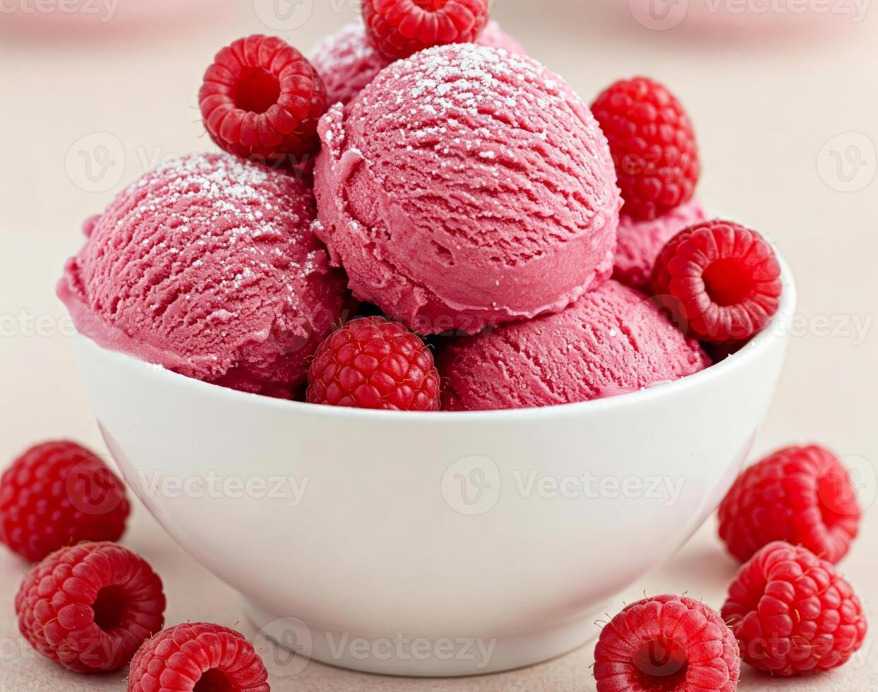 Close-up of a white bowl filled with three scoops of raspberry creamy ice cream, garnished with a fresh raspberries photo