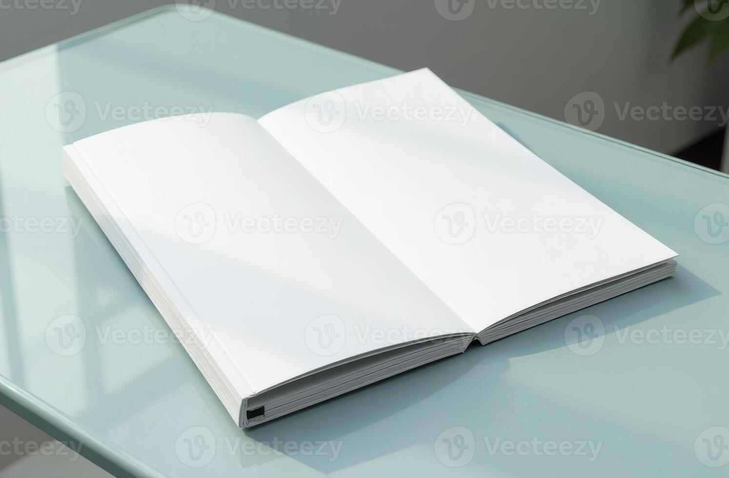 An open blank notebook resting on a glass table in a well-lit room, inviting creativity and inspiration for new ideas photo