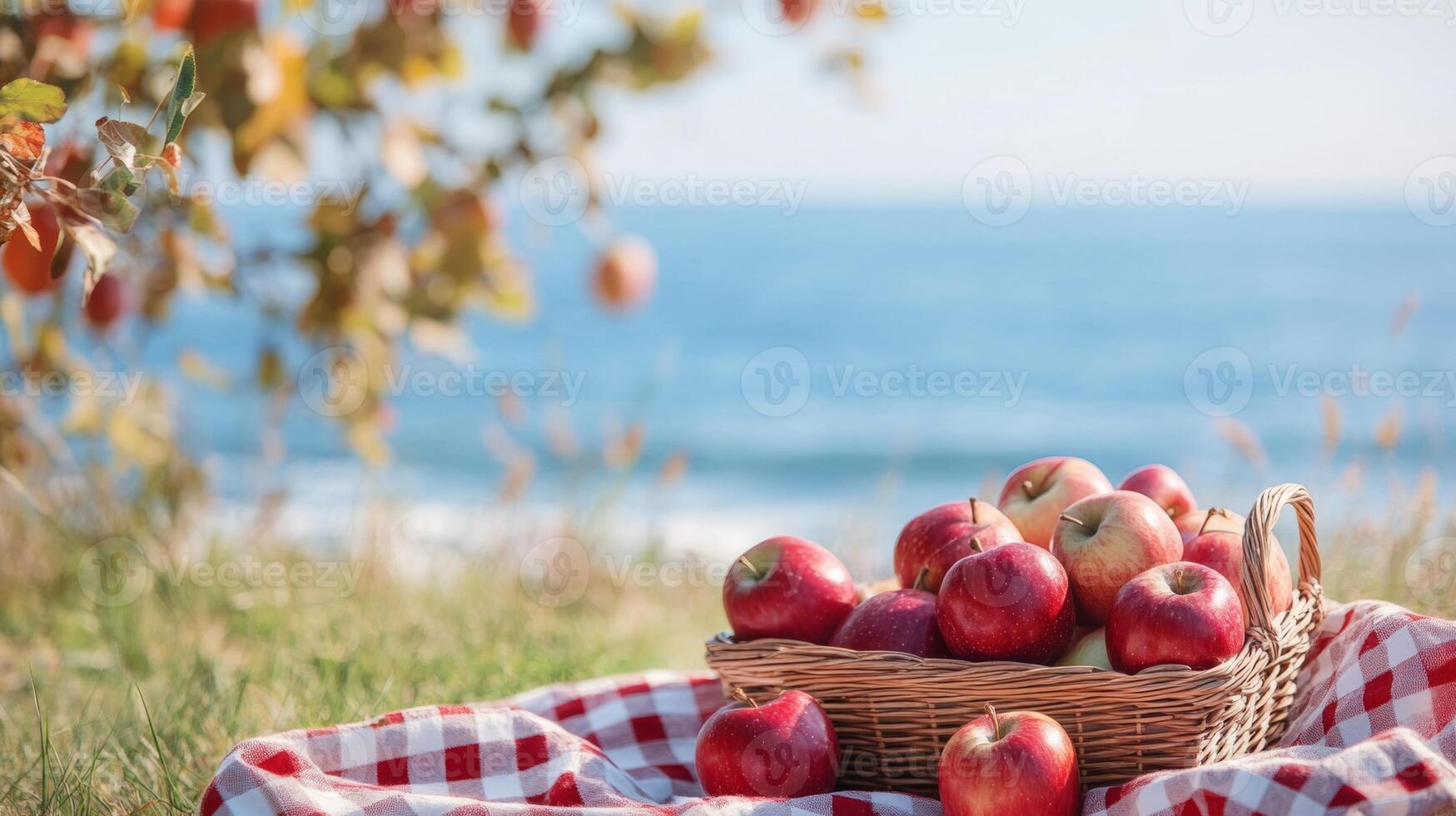 Freshly picked red apples in a basket by the beach under sunny skies during autumn photo