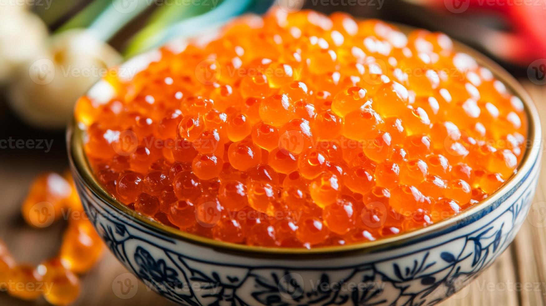Fresh salmon roe garnished in a decorative bowl on a wooden table with culinary elements in the background photo