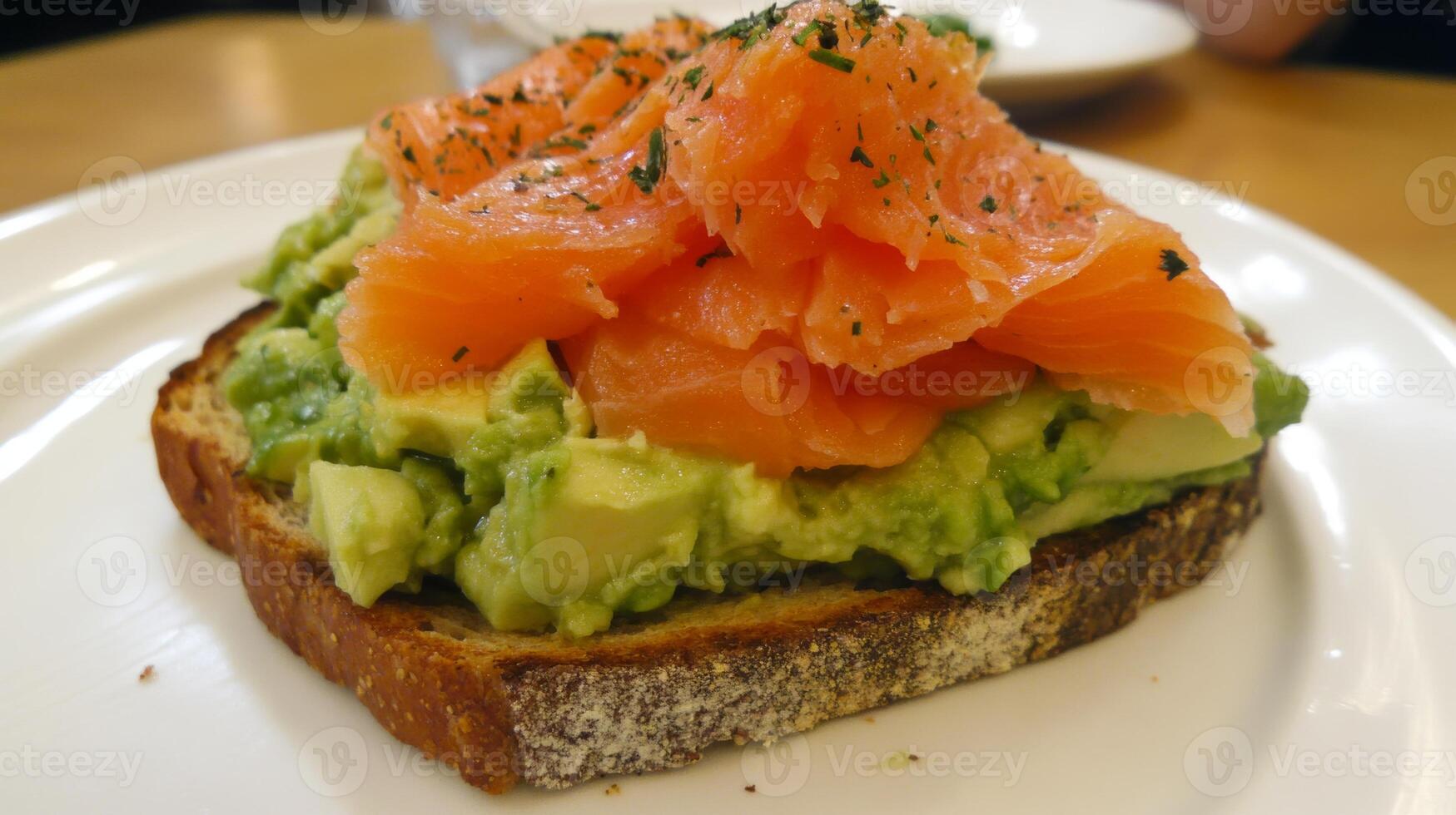 Avocado toast topped with smoked salmon served on whole grain bread at a cozy cafe photo