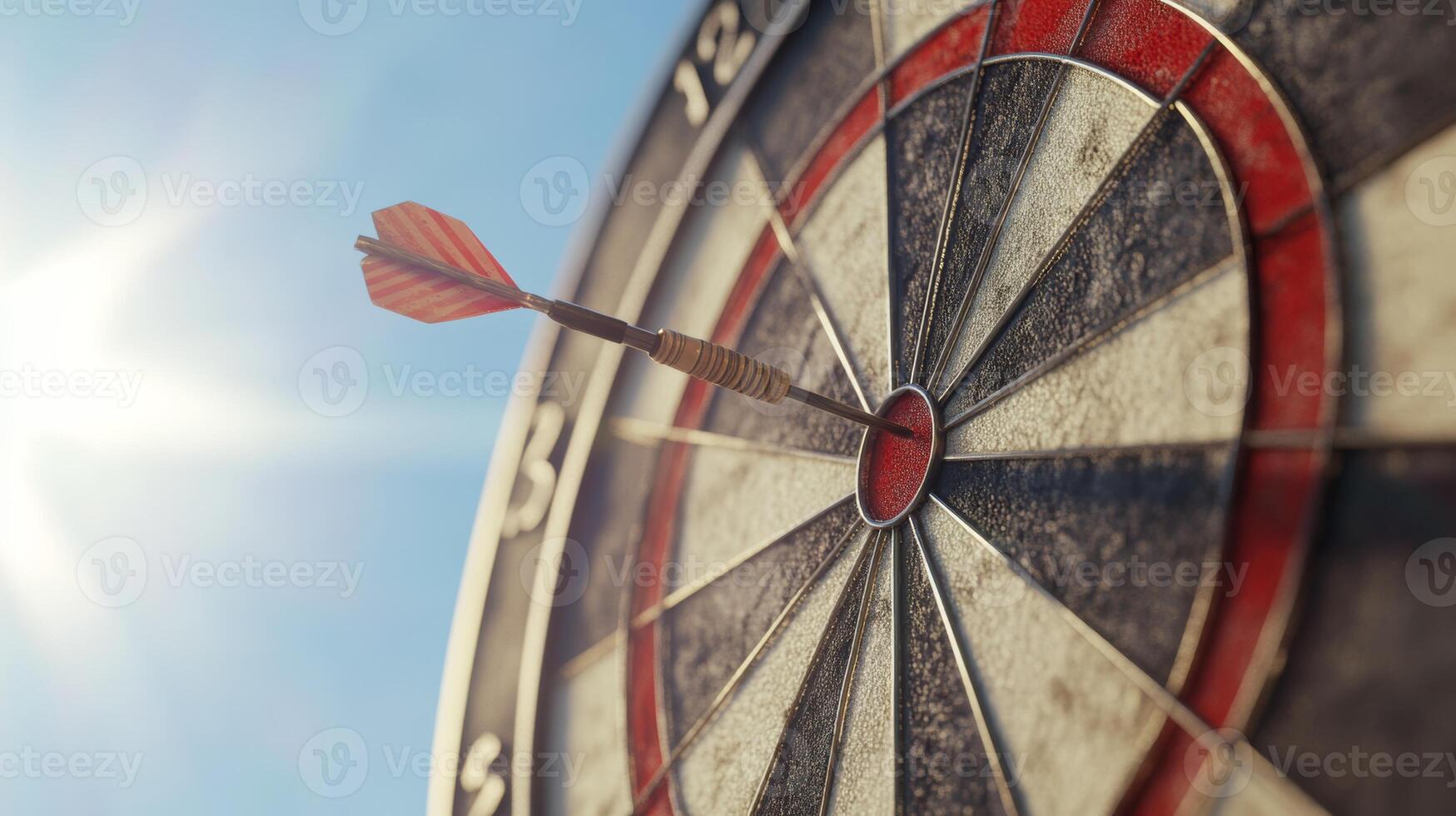 Dart stuck perfectly in the bullseye on an outdoor dartboard during a sunny day photo