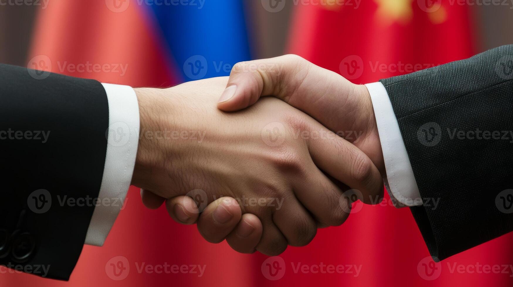 Handshake between representatives of Russia and China with national flags in the background during diplomatic meeting photo