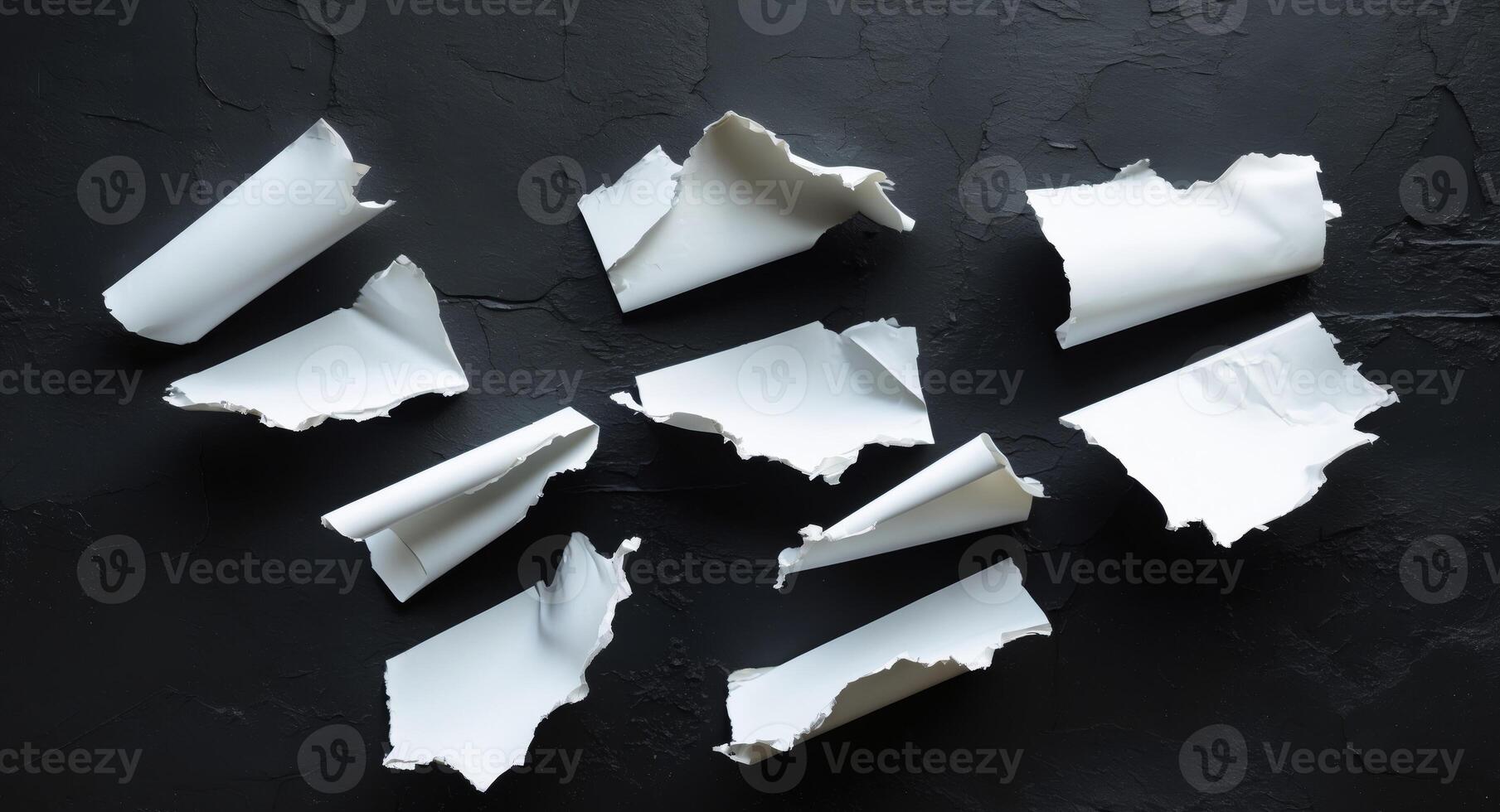 Broken pieces of white paper on a black background photo