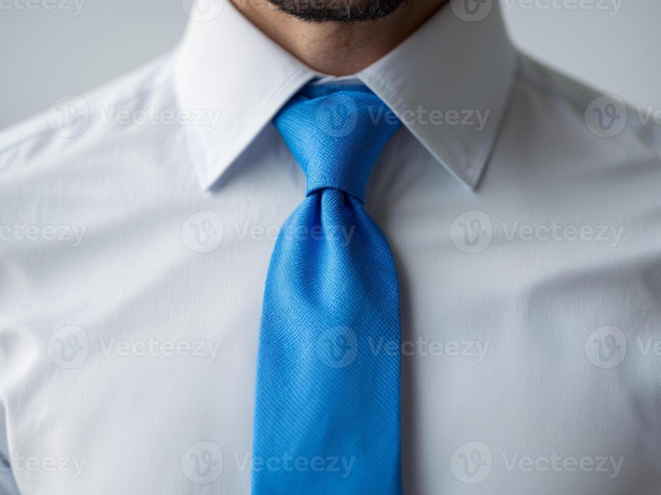 A man wearing a blue tie and a white shirt photo