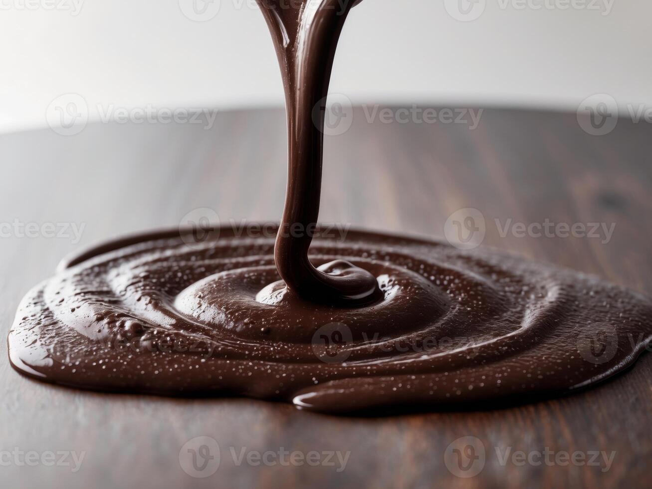Decadent Pour. A CloseUp of Rich Chocolate Glaze Flowing onto a Wooden Surface. photo