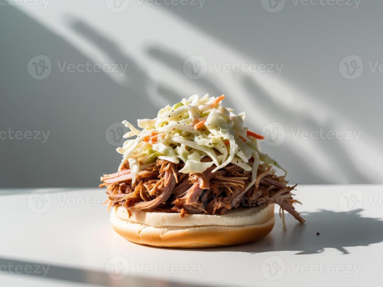 A pulled pork sandwich with coleslaw on a white table photo