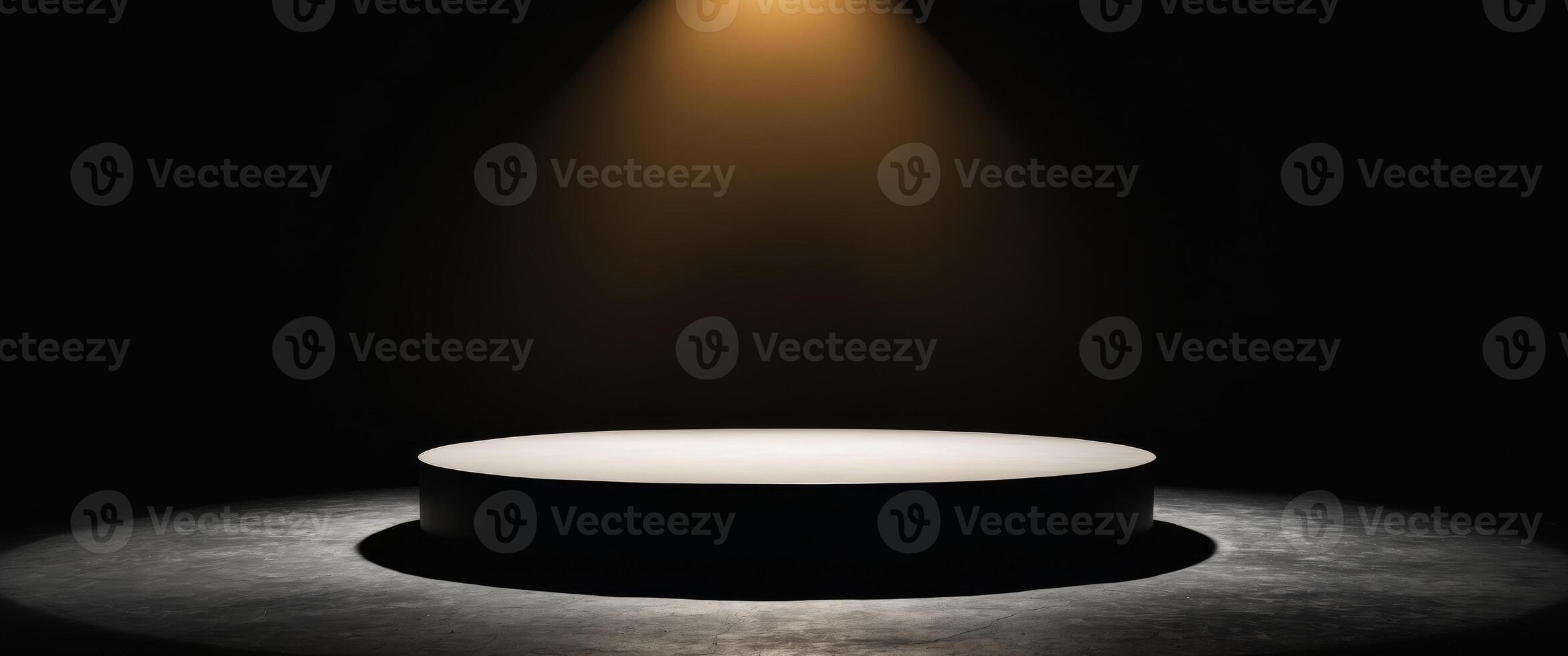 A spotlight shines on a round table in a dark room photo