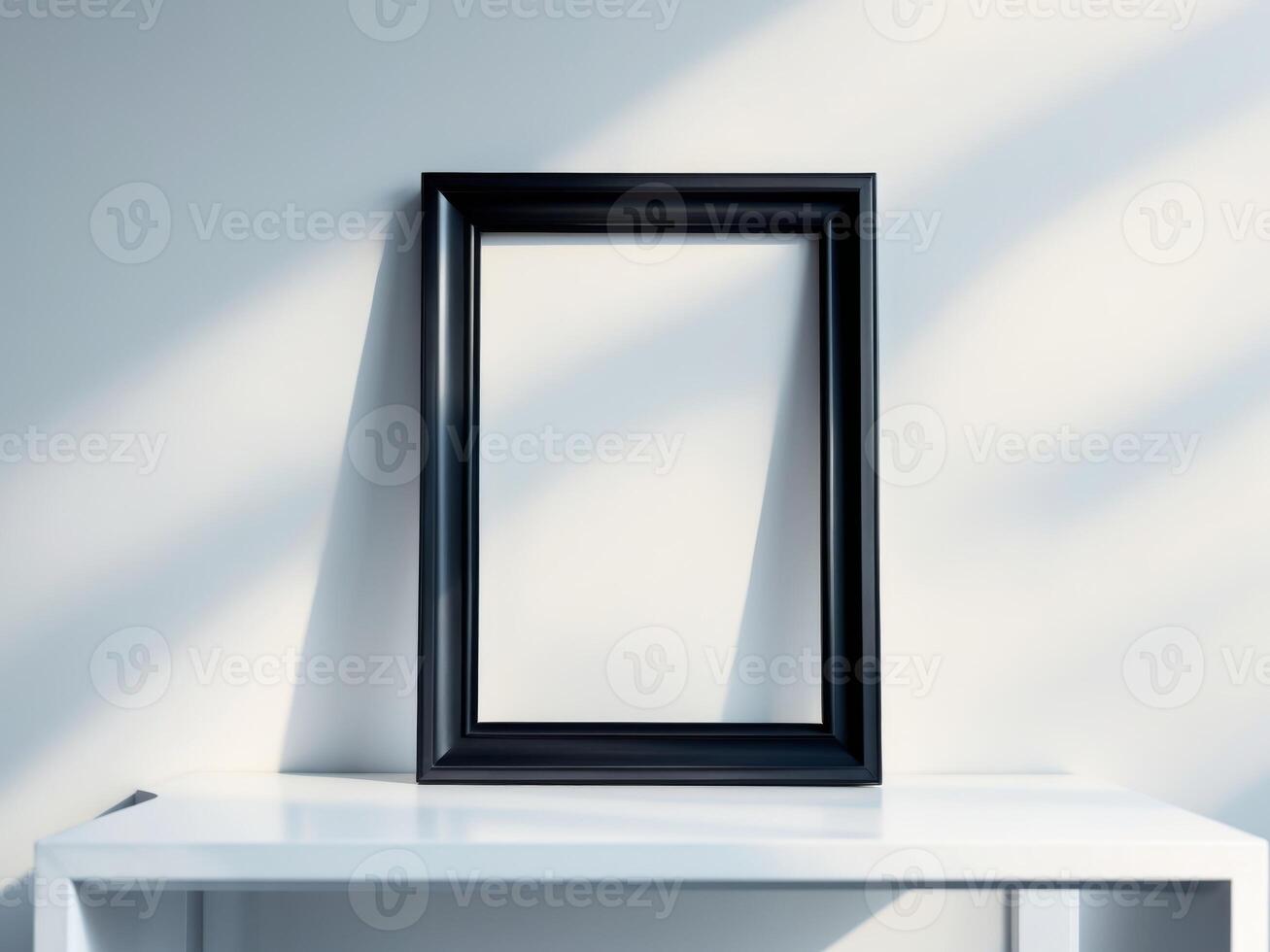 A black frame sitting on a table in front of a white wall photo
