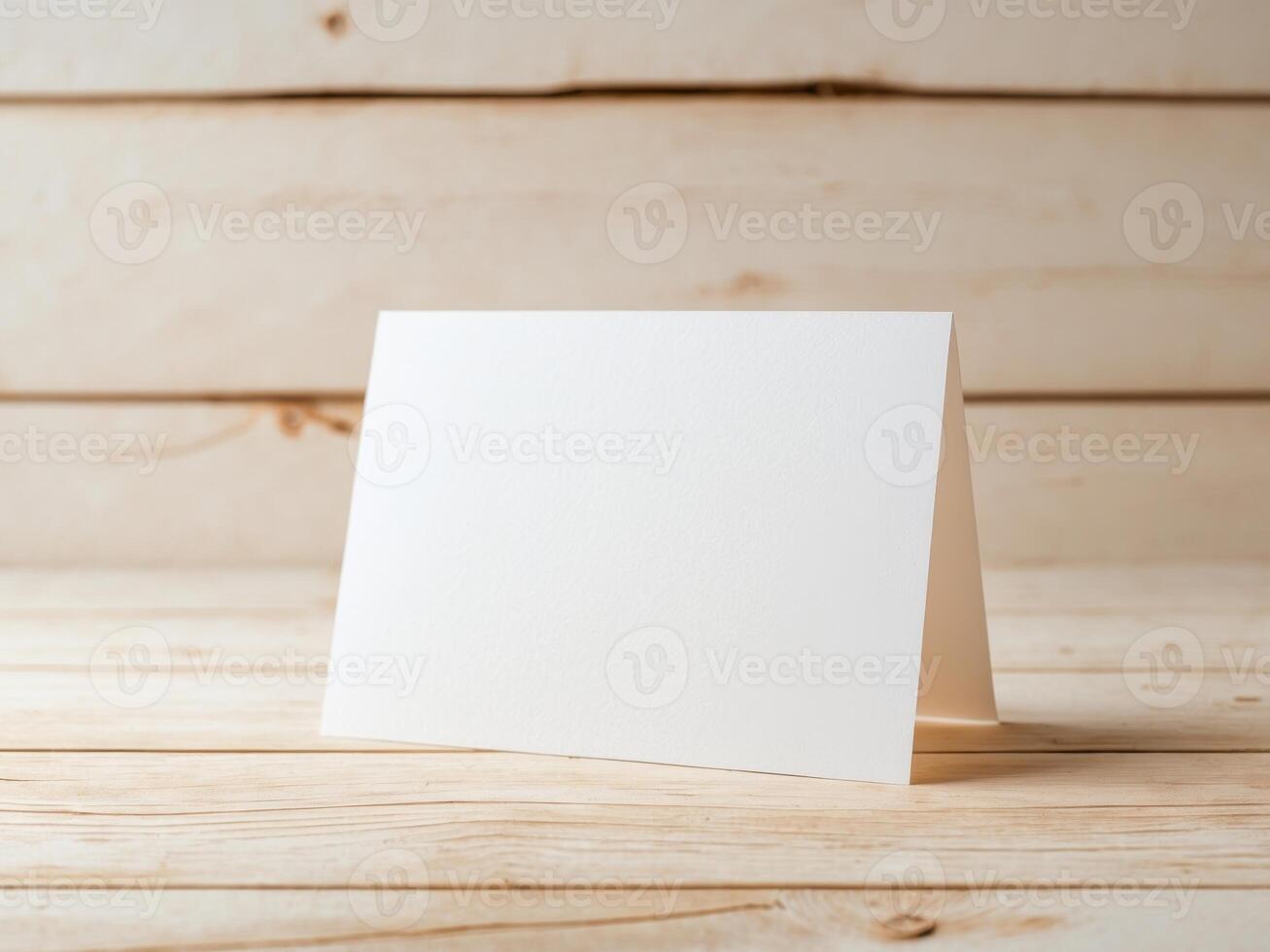 Blank white card on wooden table photo