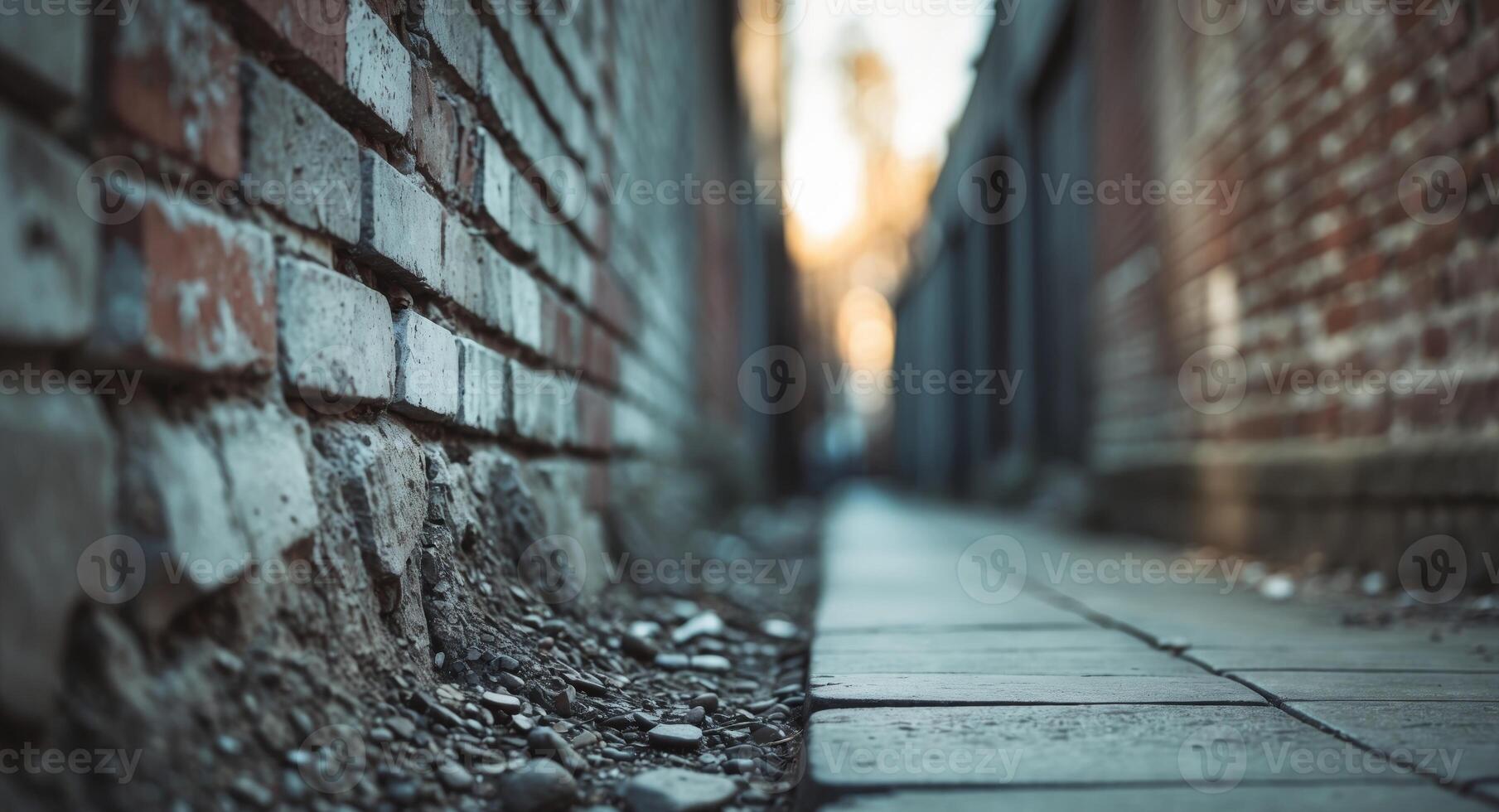 An alleyway with a brick wall and a sidewalk photo