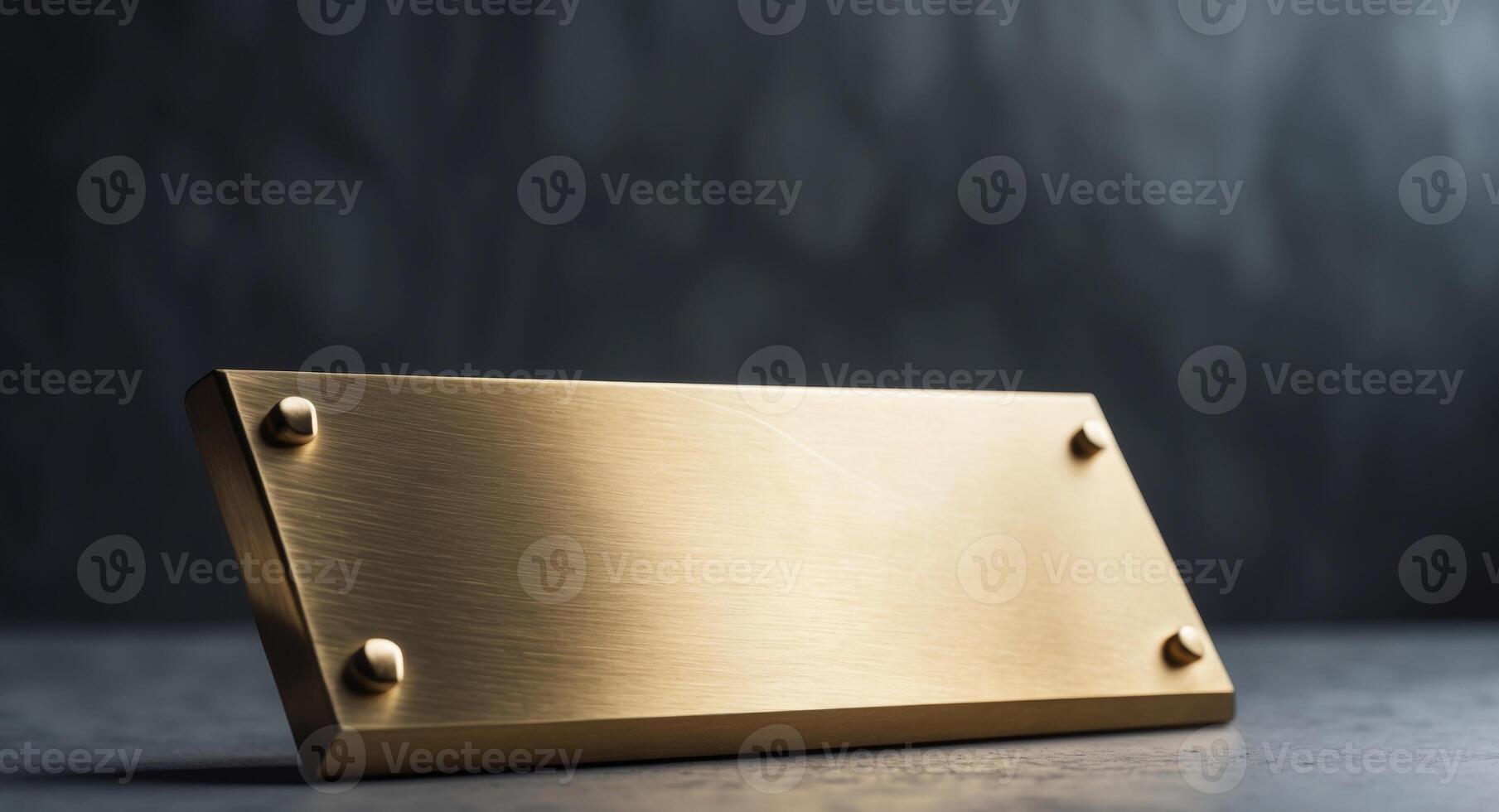 Elegant, blank golden plate with screws on a dark background, ready for inscription. photo