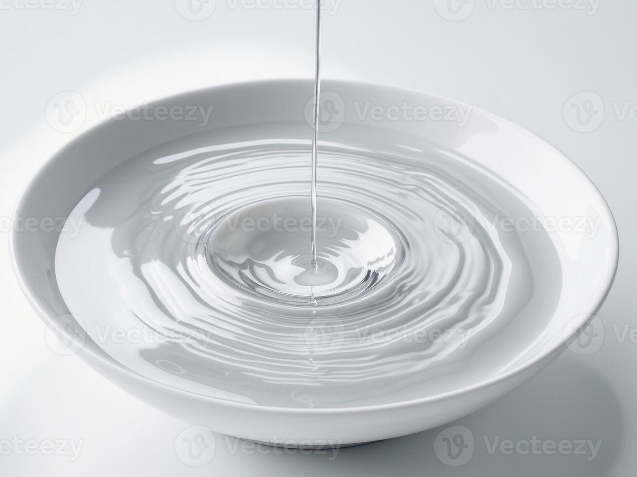 Water Dropping Into a White Bowl Creates Ripples a Minimalist Zen Image. photo
