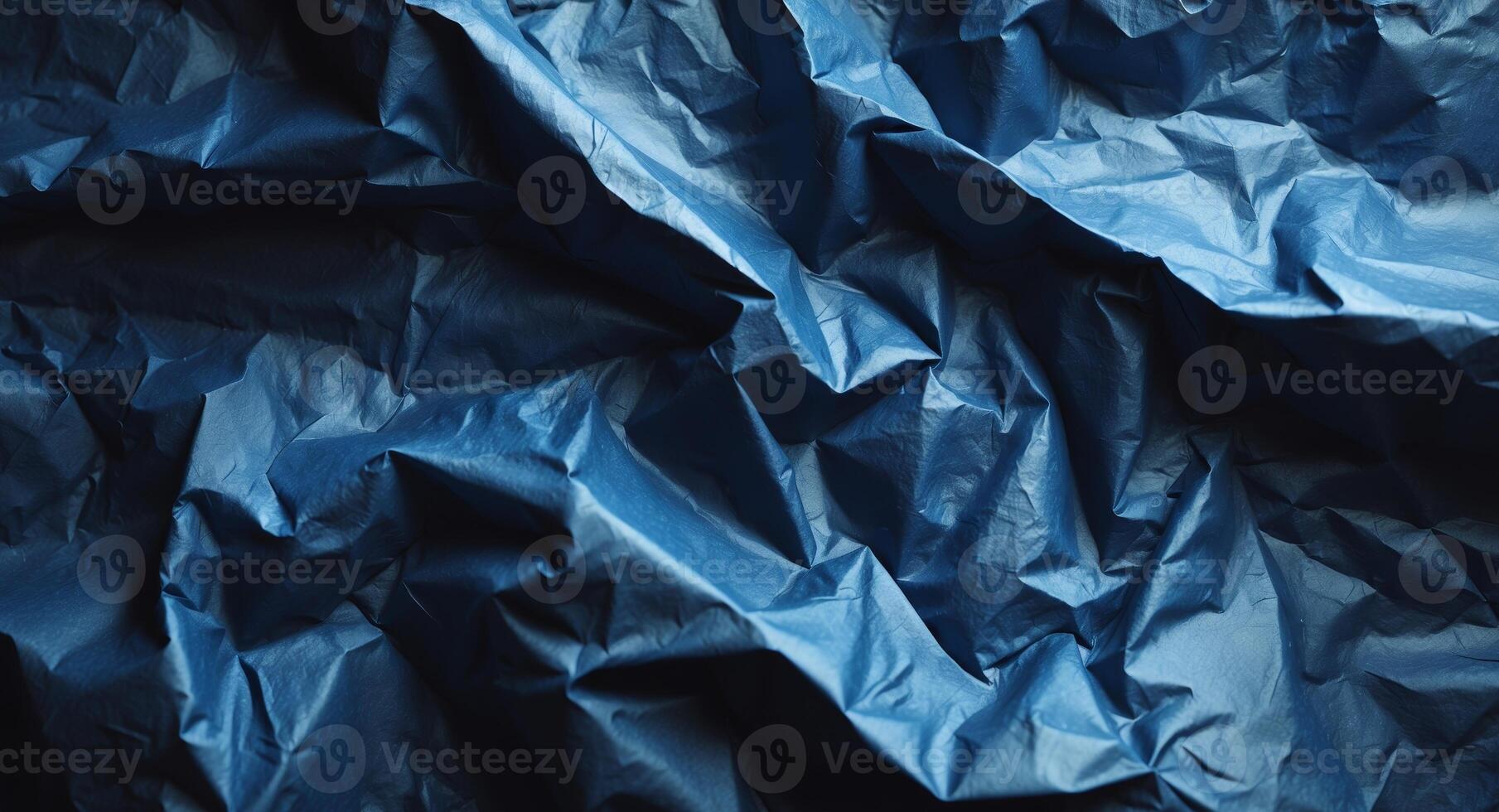 Blue crumpled paper background with black background photo