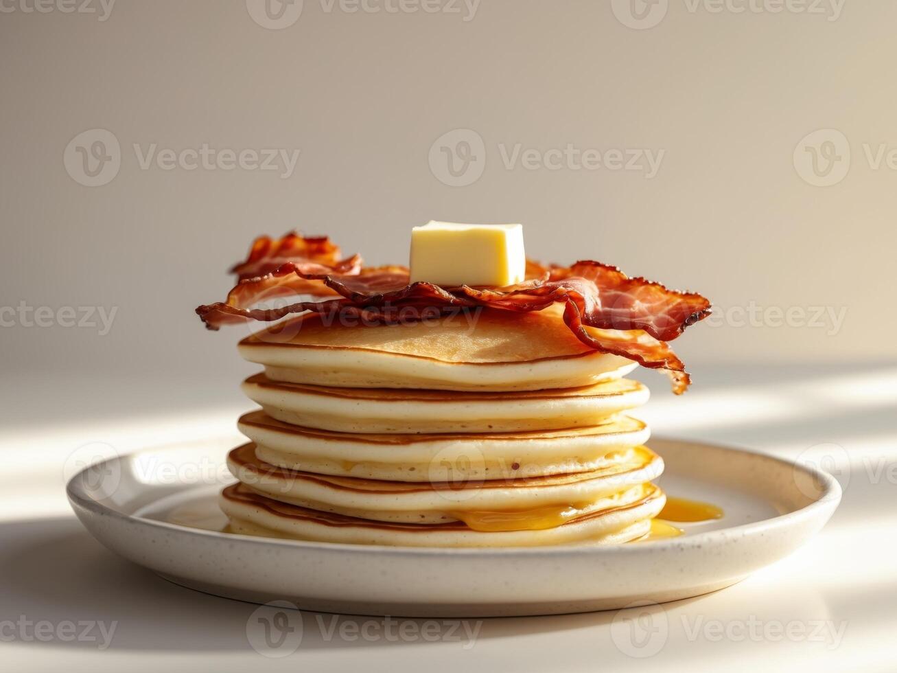 A stack of pancakes with bacon and butter photo