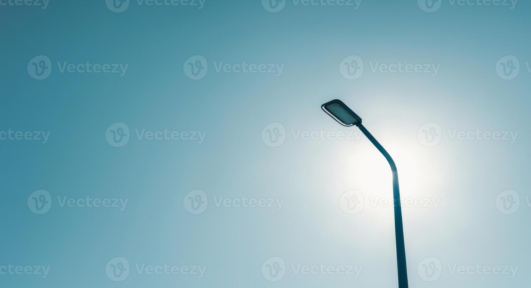 A street light is shown against a blue sky photo