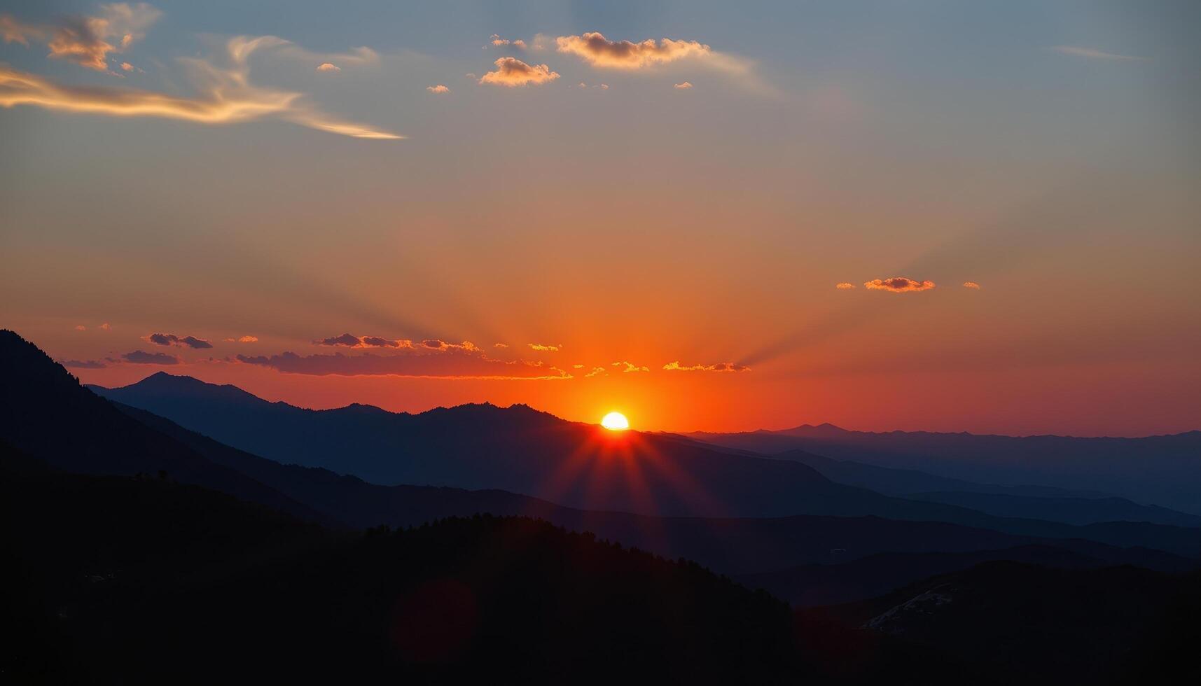 the sky turns brilliant orange as the sun sets behind a line of rocky peaks. photo