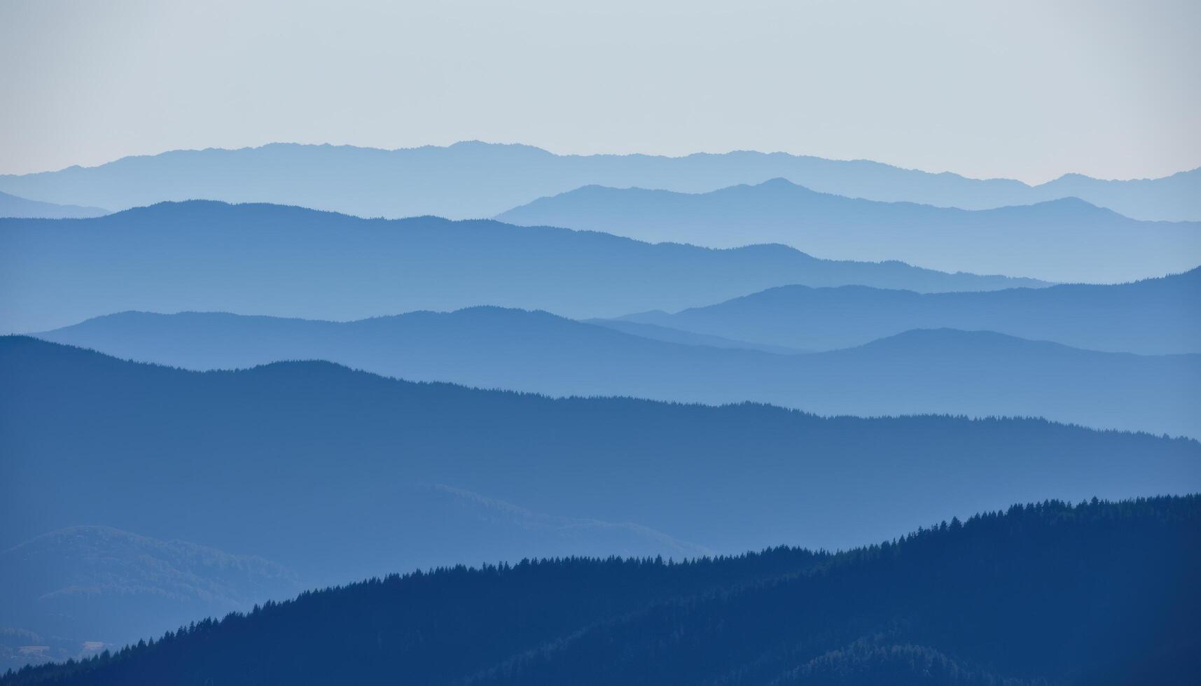 a layered mountain range fading into blue haze as they reach the horizon. photo