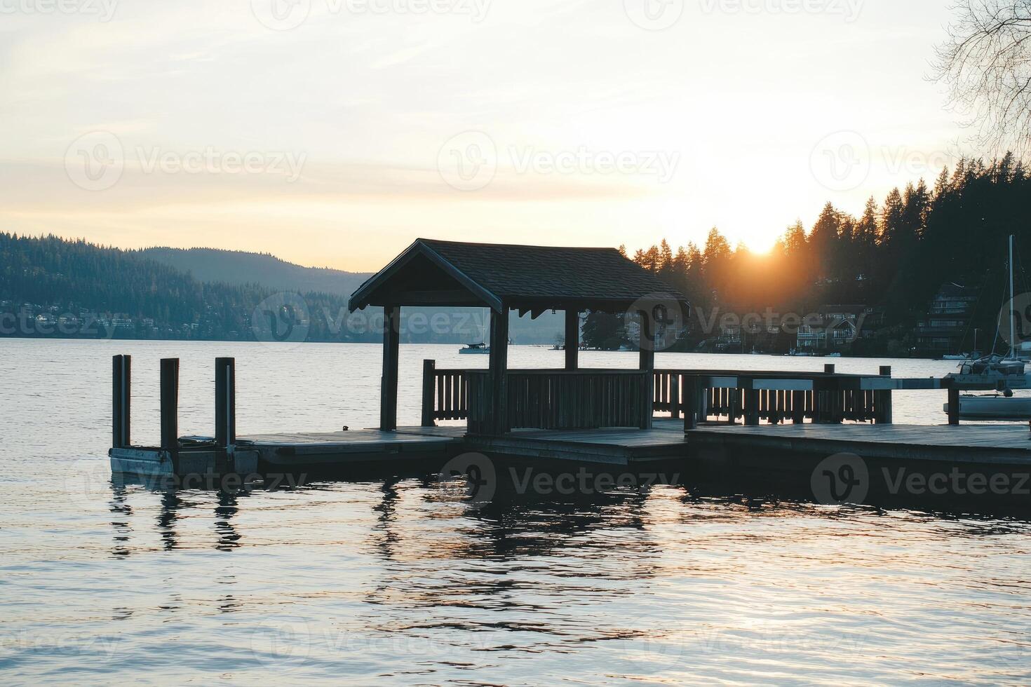 A dock with a gazebo on the water at sunset photo