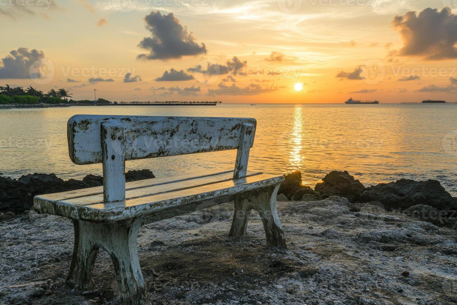 A bench sitting on the beach photo