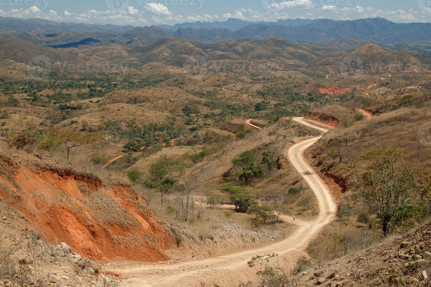 A dirt road winding through a mountainous area photo