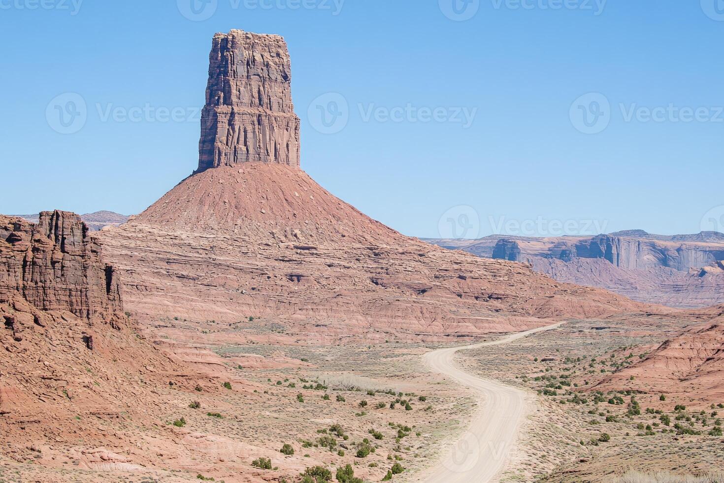 A dirt road that goes through a desert area photo