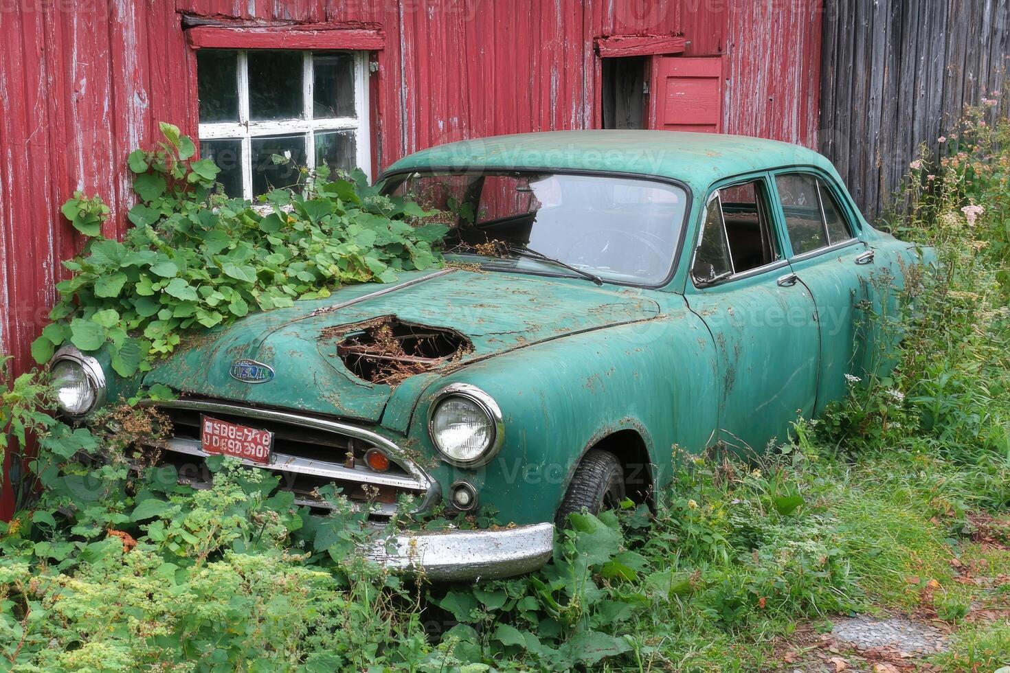 An old car is sitting in front of a barn photo