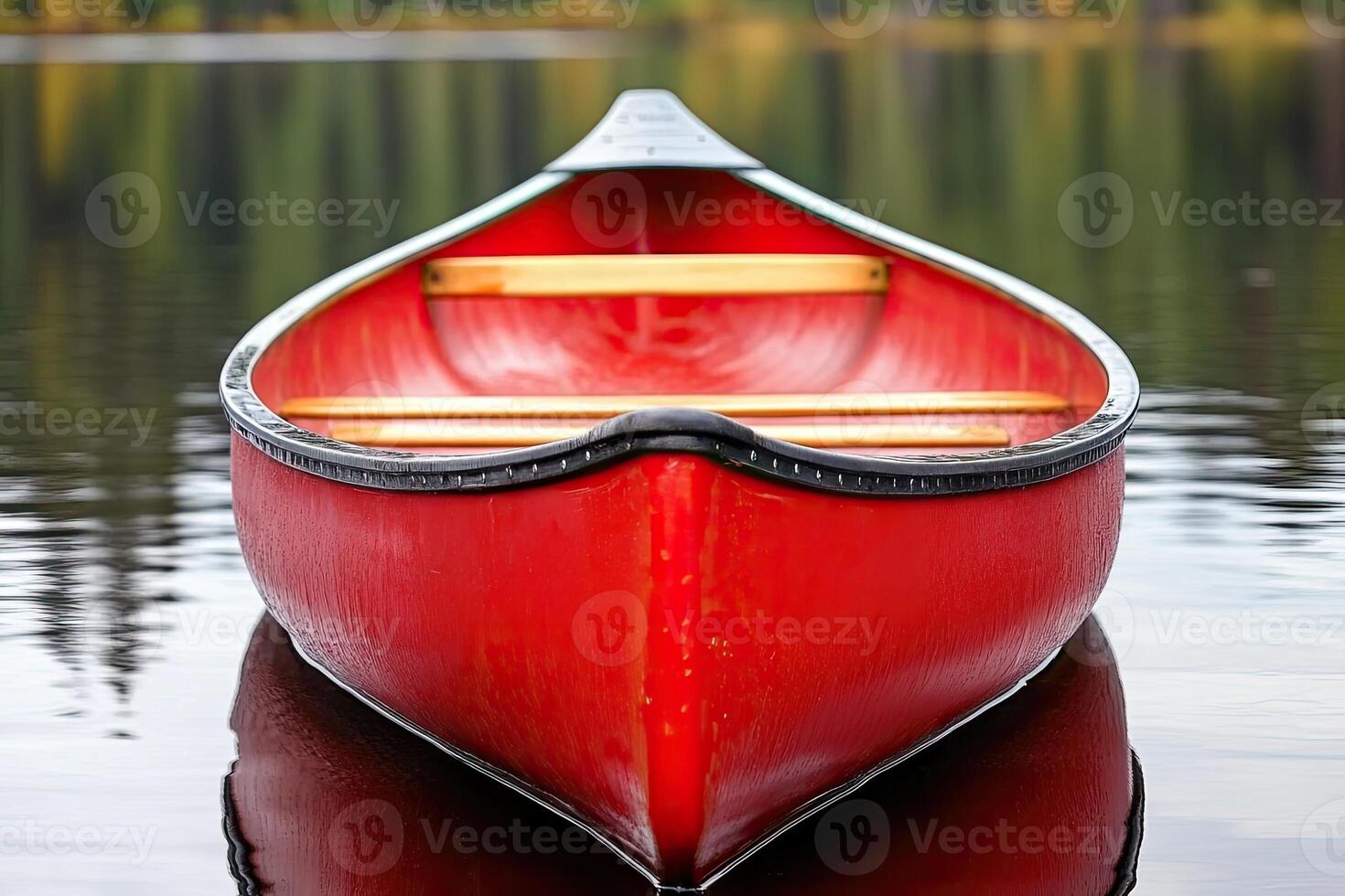 Red canoe on calm lake water. Close-up view of the boat's hull photo