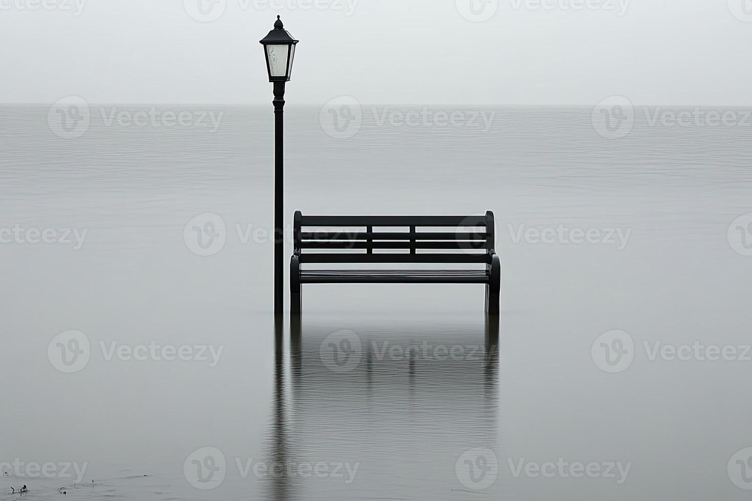 Solitary bench and lamppost submerged in calm, misty water photo