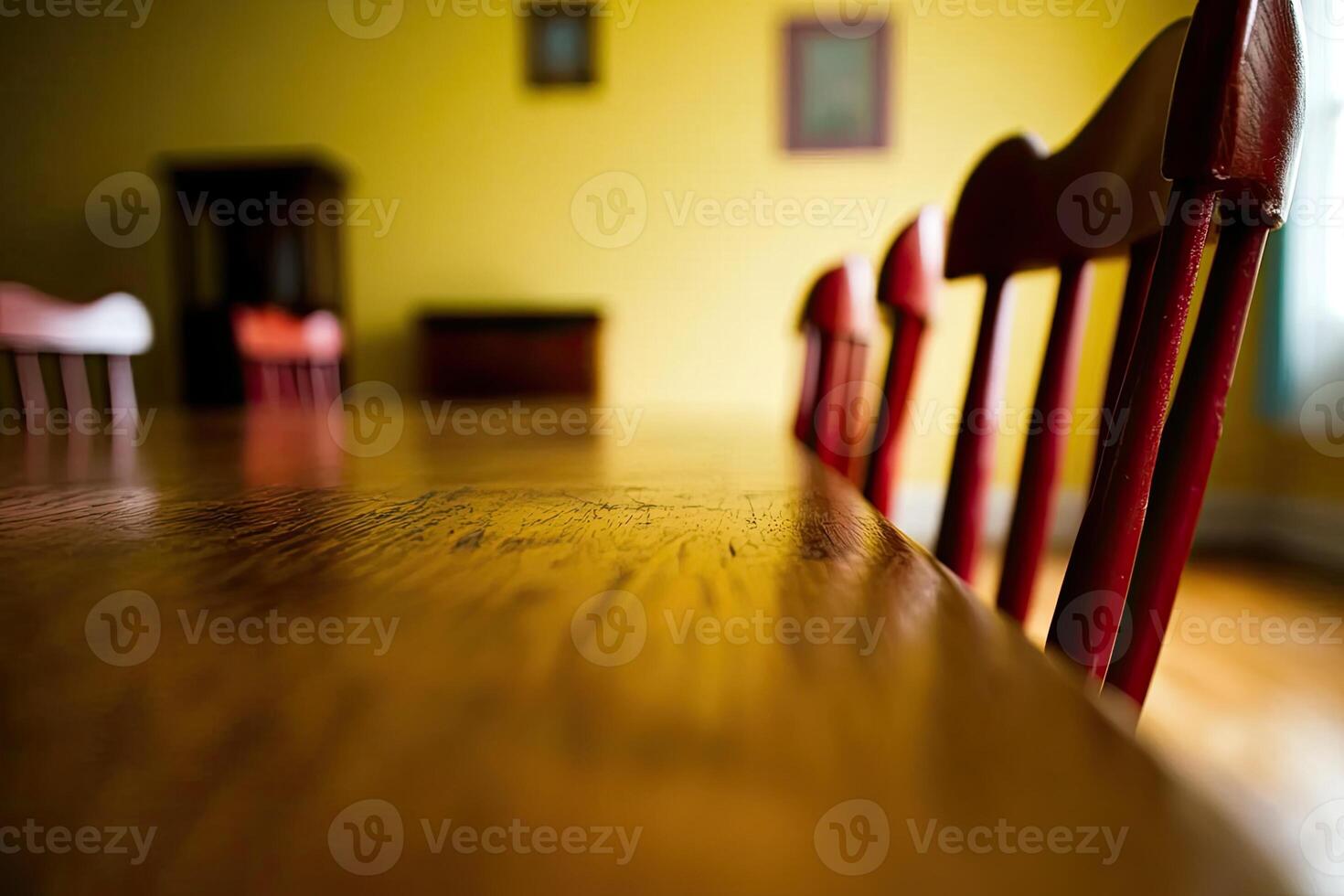 A wooden table with red chairs in front of a yellow wall photo
