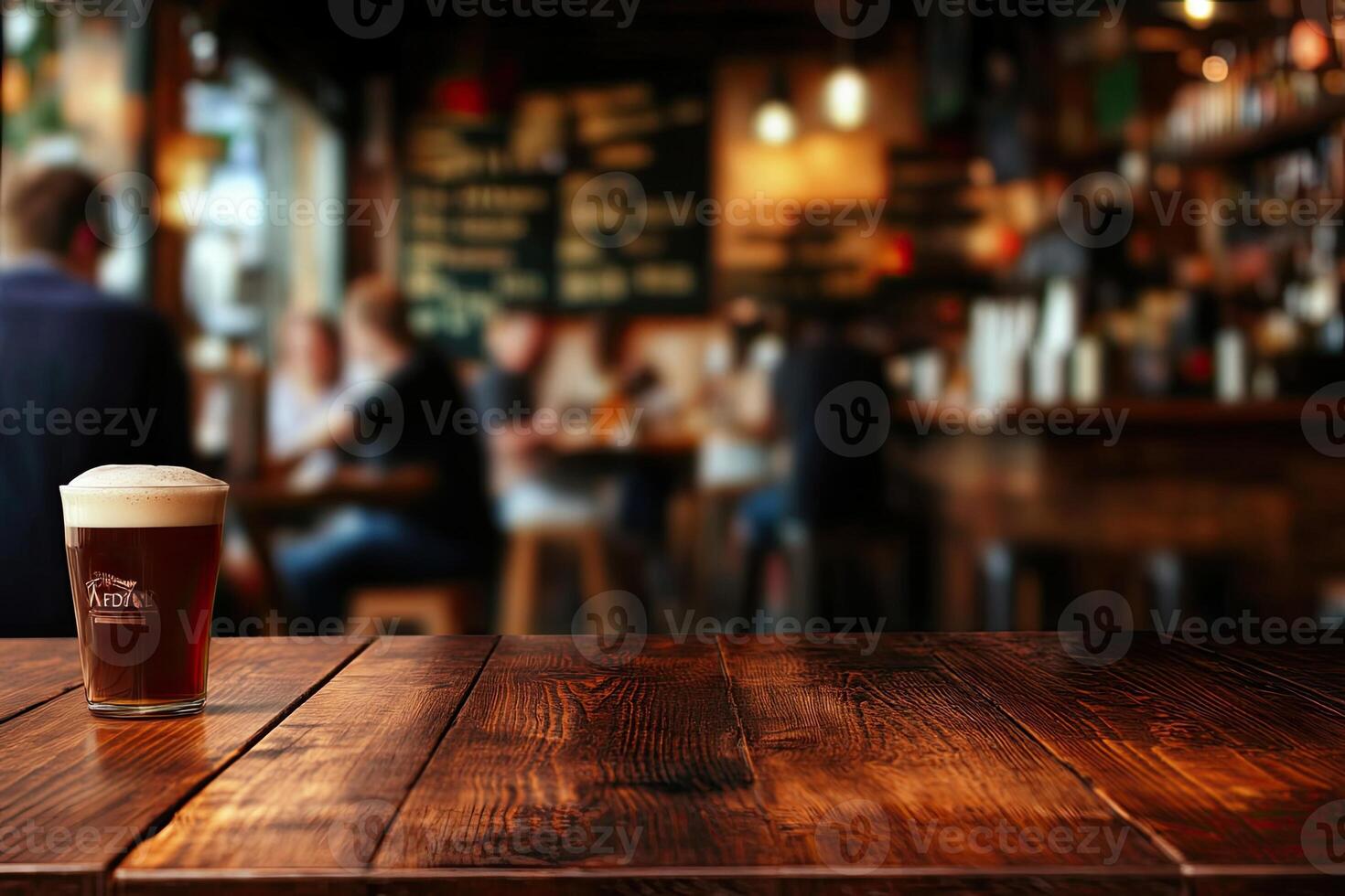 A glass of beer sitting on a wooden table photo