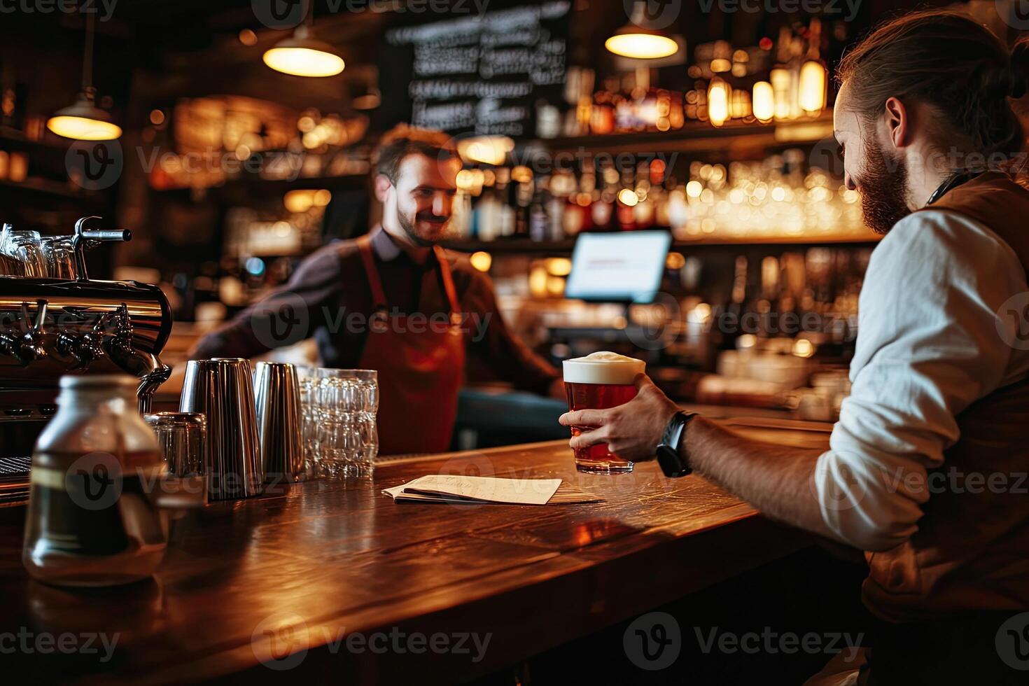 A man is holding a beer at a bar photo