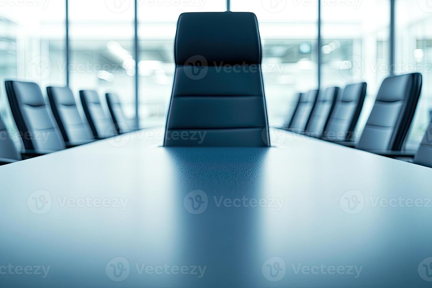 A conference table with black chairs in front of a window photo