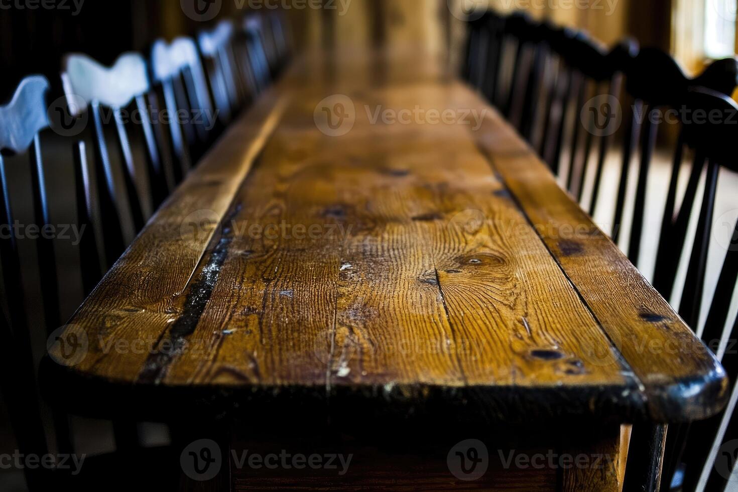 A long wooden table with black chairs photo