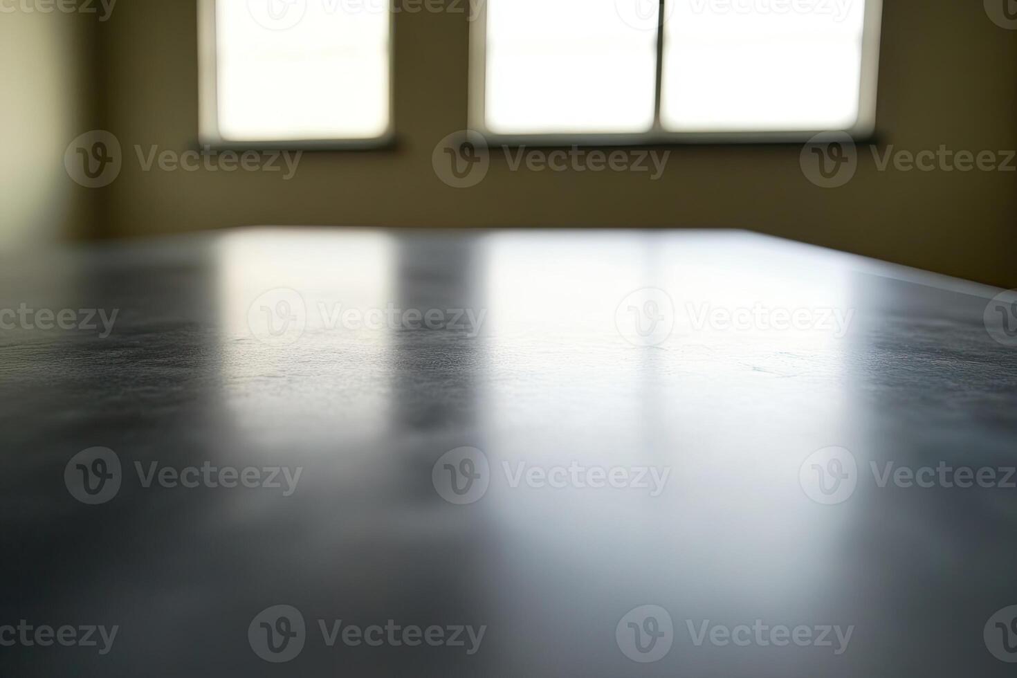 A table with a black surface in front of two windows photo