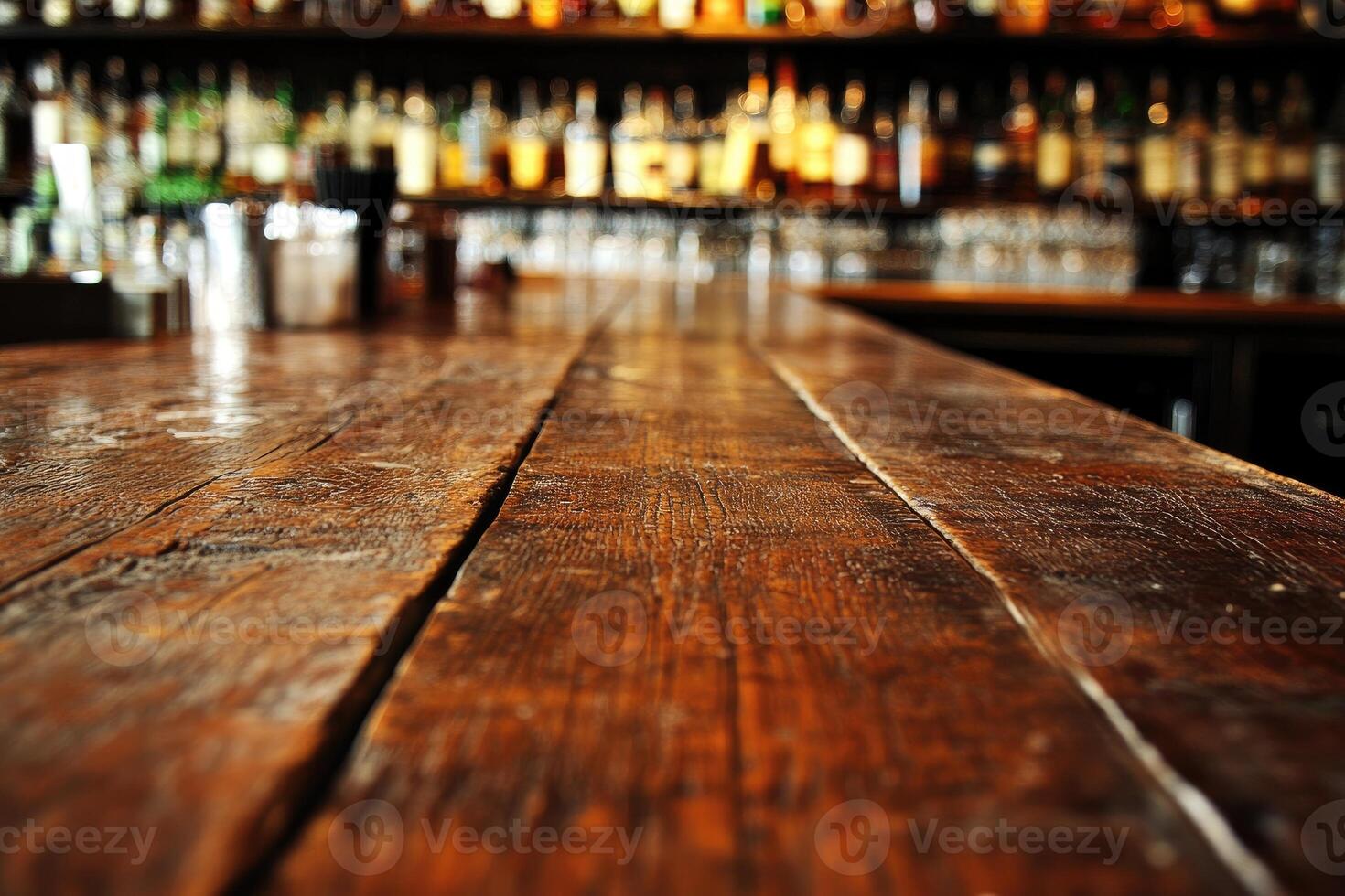 A wooden bar counter with many bottles of alcohol photo