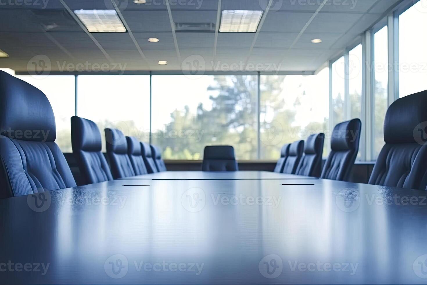 A conference table with black leather chairs in front of a large window photo
