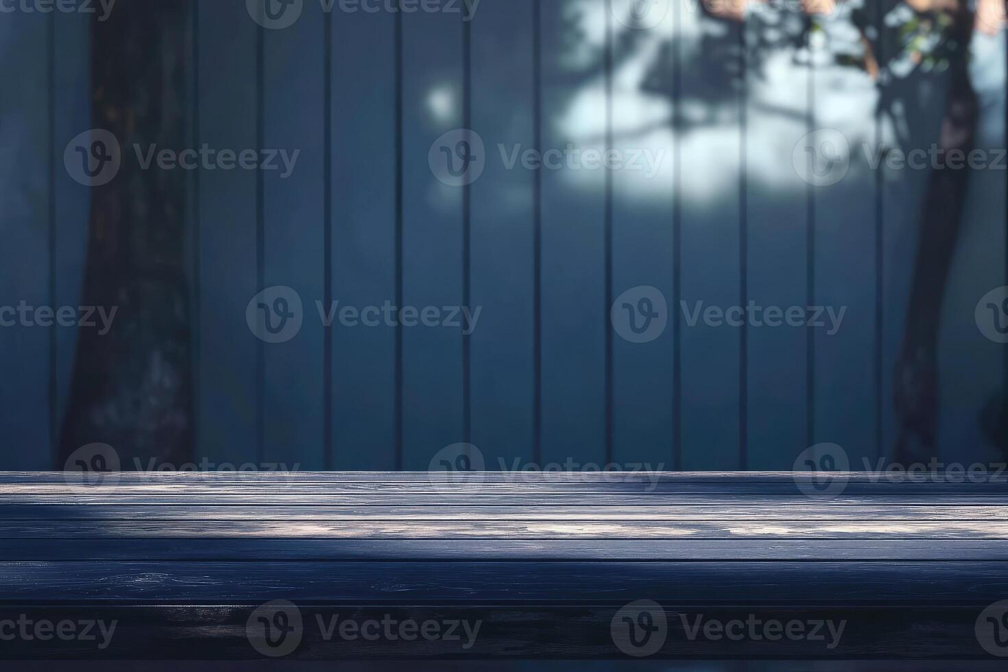 An empty wooden table in front of a blue wall photo