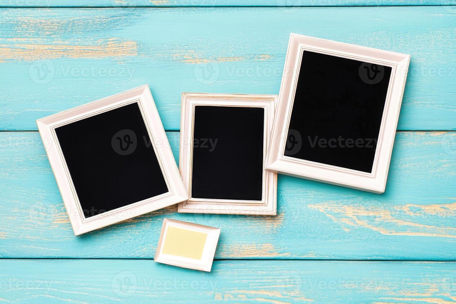 Three empty frames on a blue wooden table photo