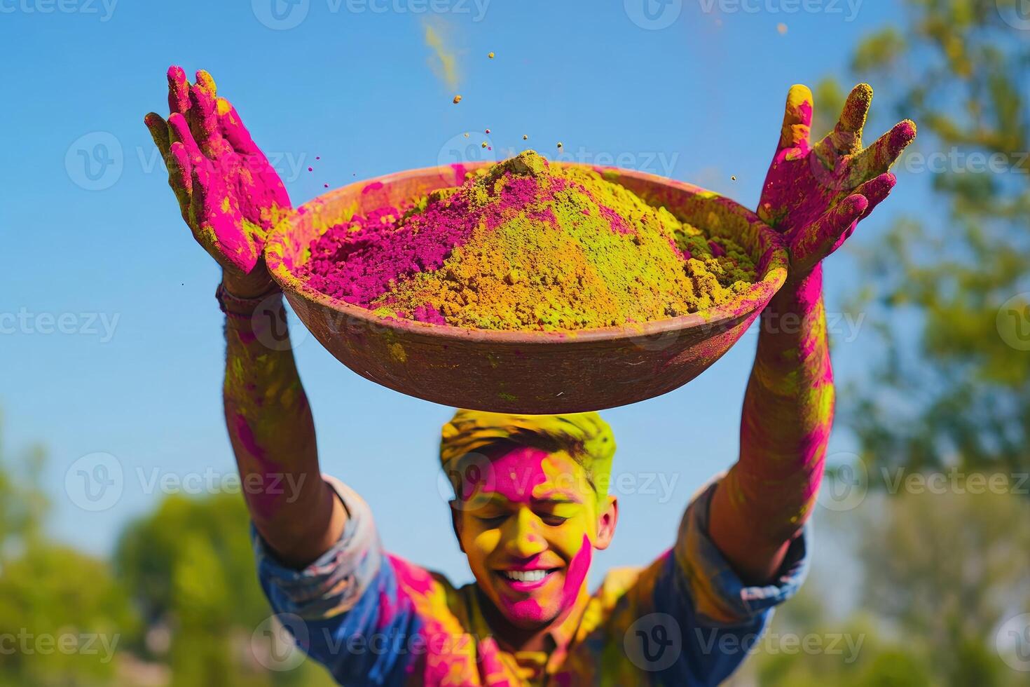 A man holding up a bowl of colorful powder photo