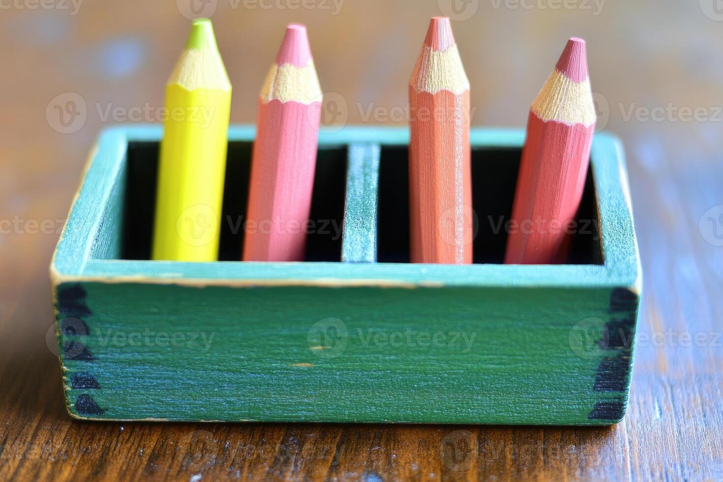 A wooden box with four colored pencils in it photo