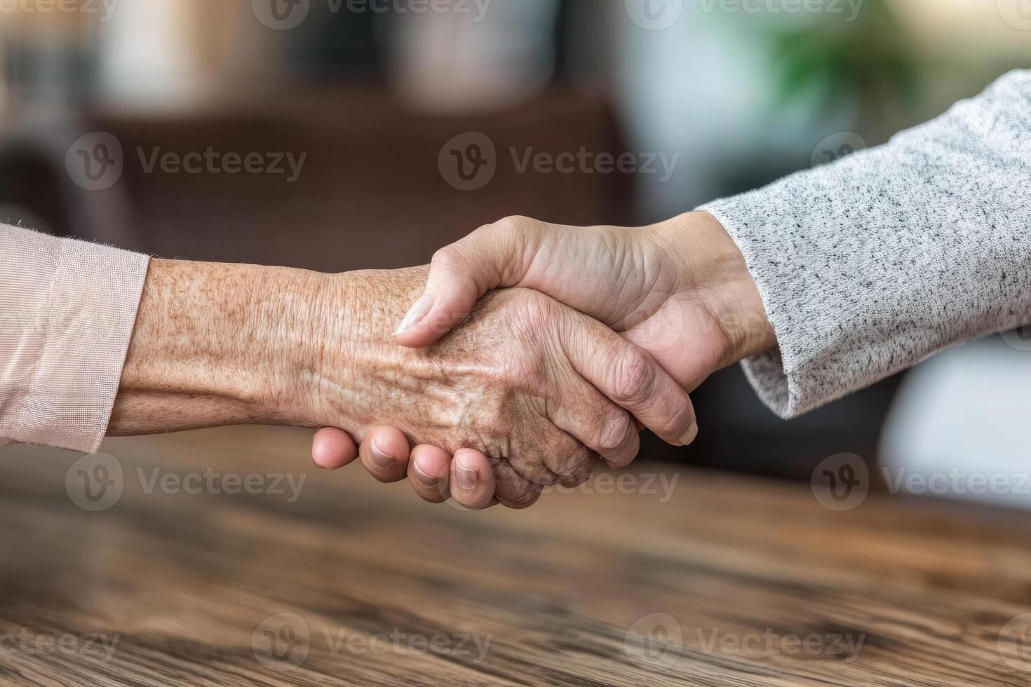 A handshake between two people. Close-up view of hands clasped together. Senior and younger individuals connect photo