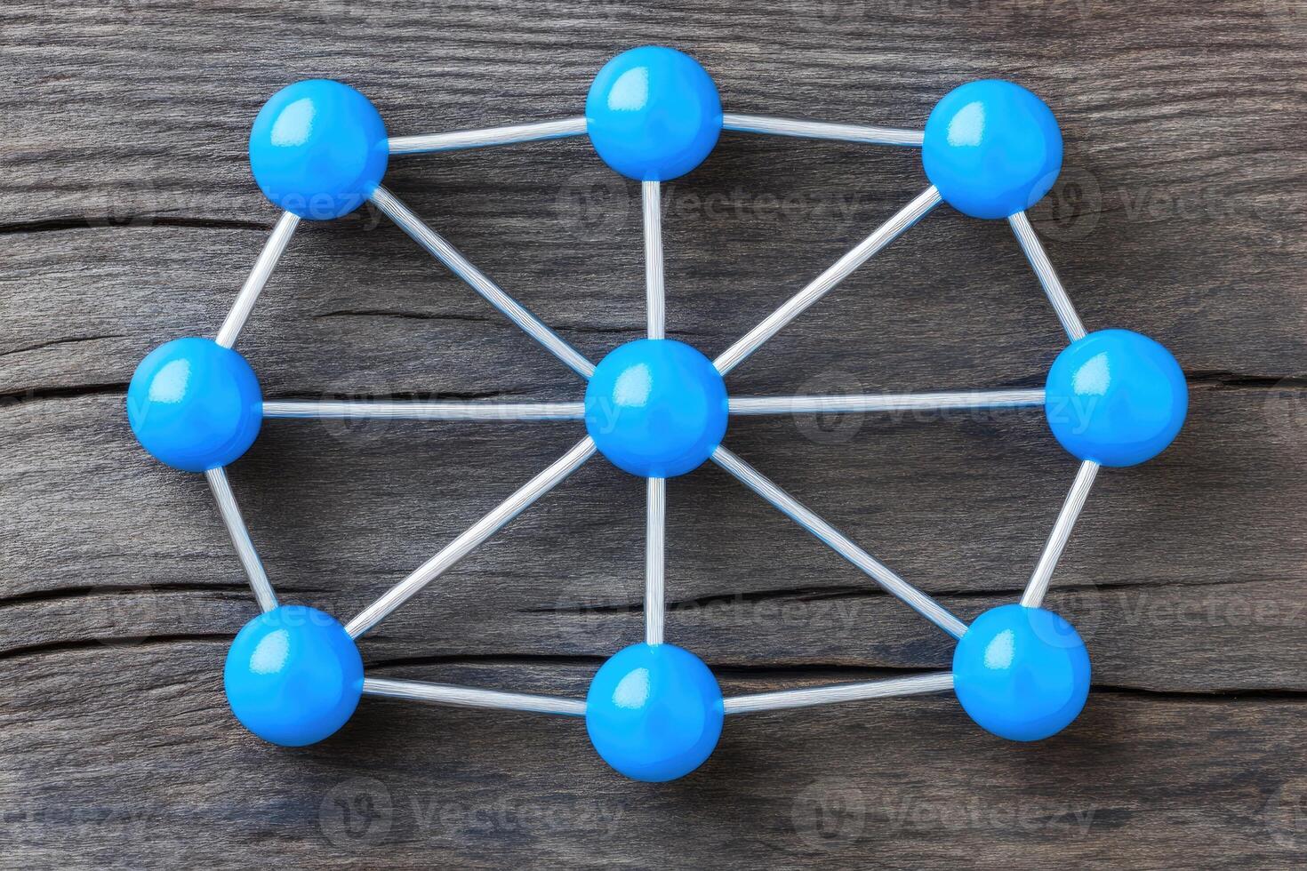 Blue spheres arranged in a network on a wooden table photo